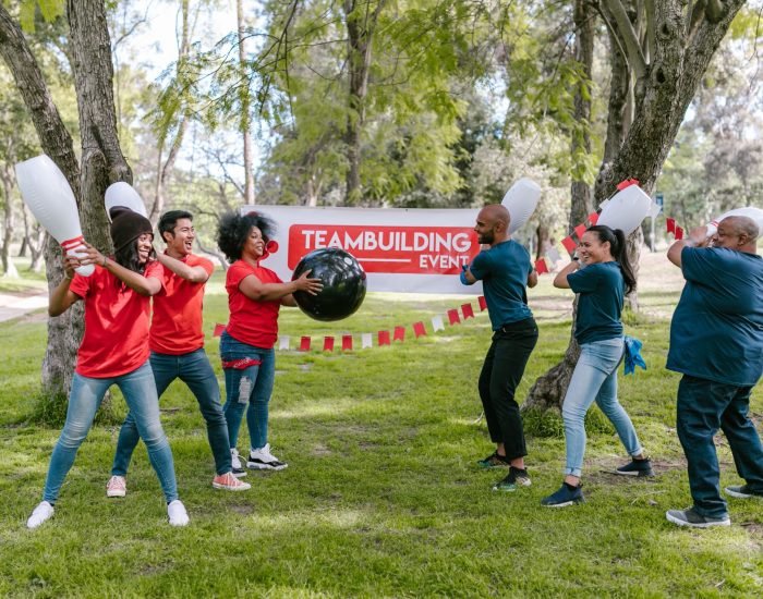 Dynamic outdoor team building activity with diverse group playing in the park.
